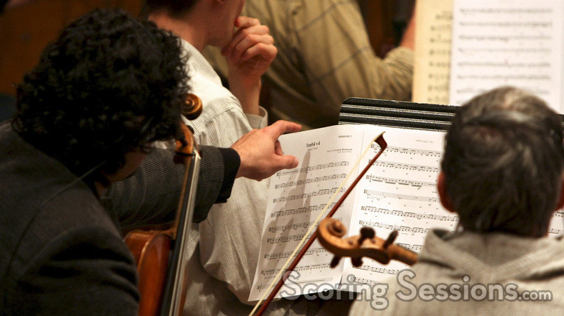 The violins studying the score
