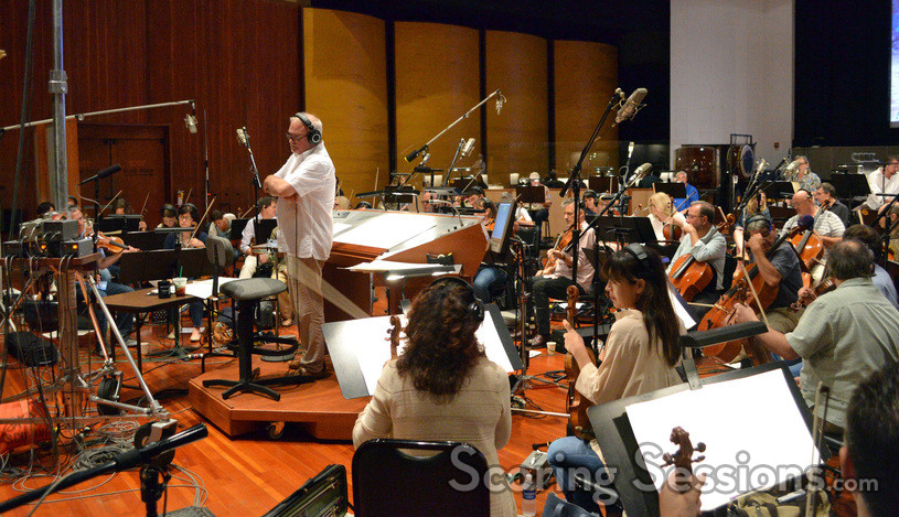 Conductor Don Harper gets feedback from the booth between takes