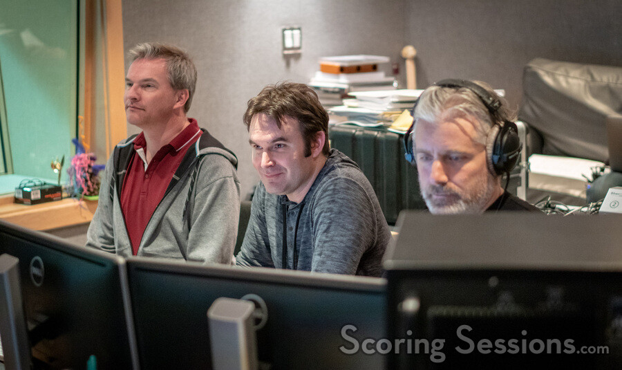 Additional music composer / orchestrator Marcus Trumpp, additional music composer Brandon Roberts, and score producer Buck Sanders listen to a cue