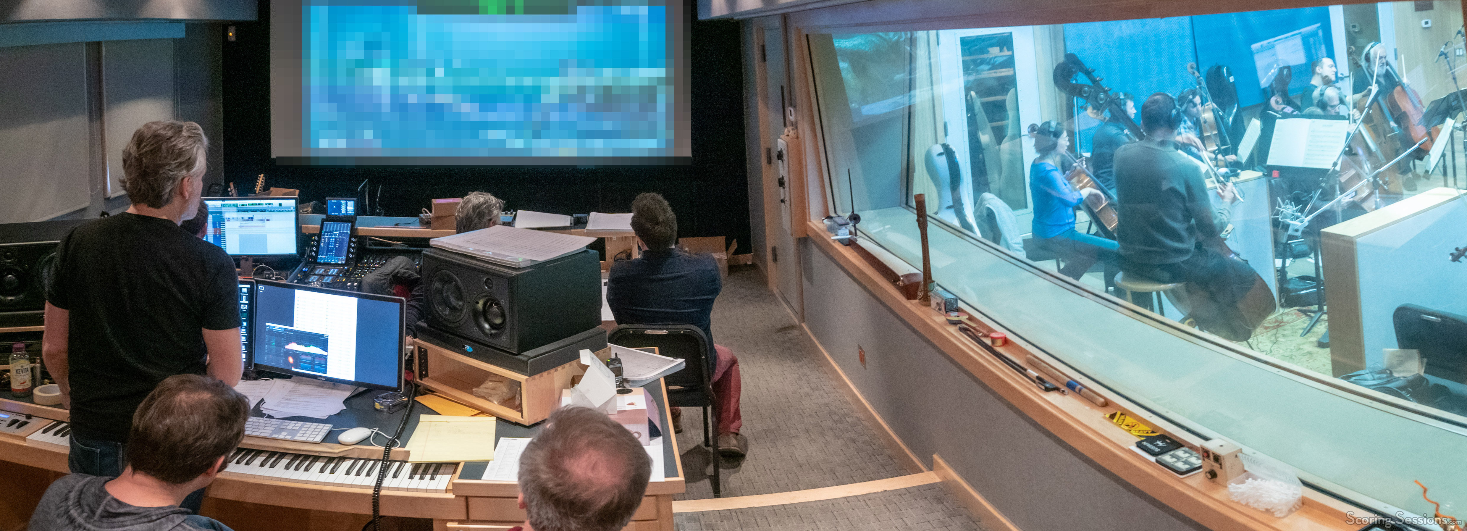 The music team watches the playback as a cue is recorded